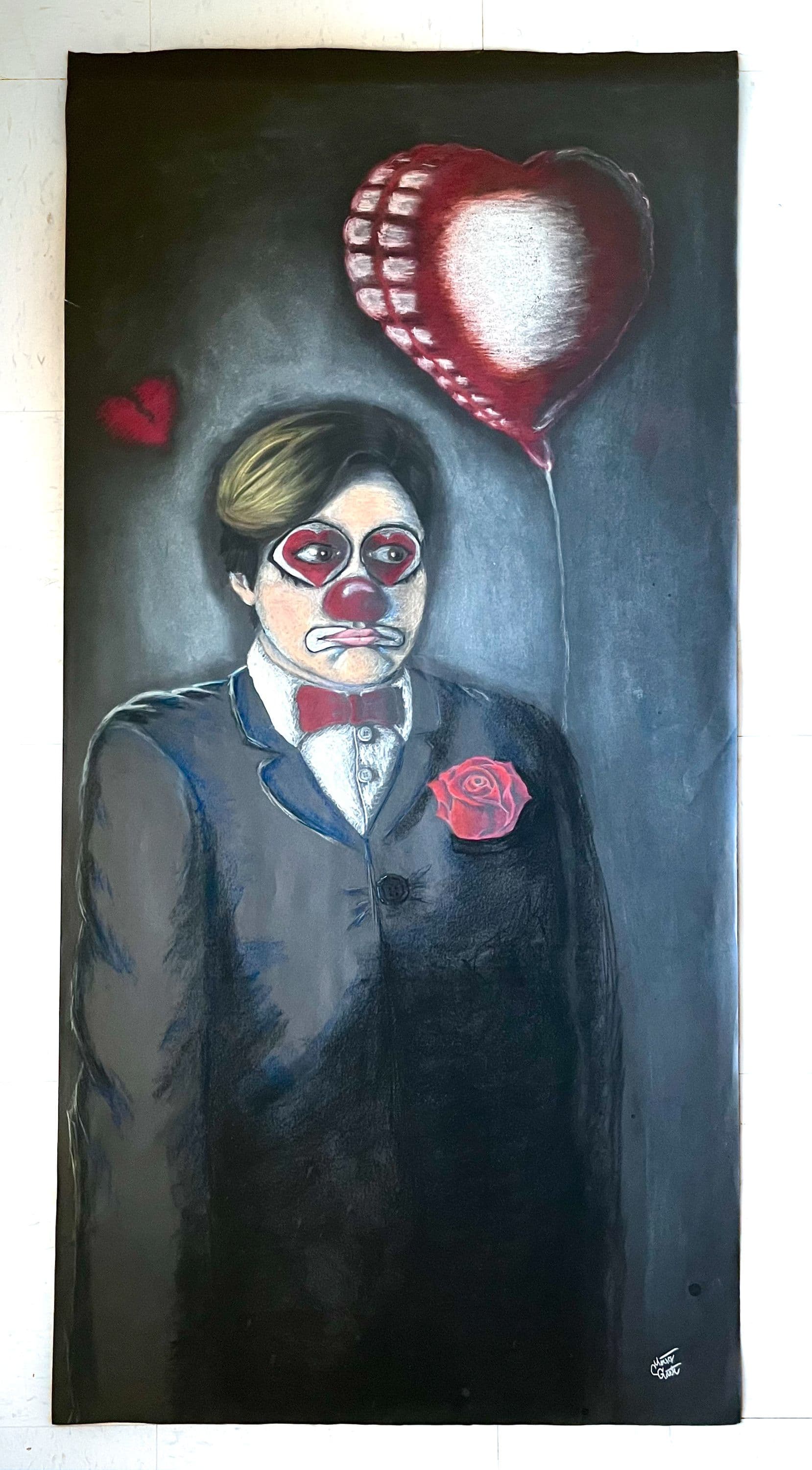 A person holding a heart dressed in clown attire